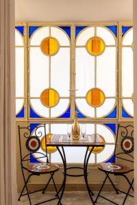 einen Tisch und zwei Stühle vor einem Buntglasfenster in der Unterkunft ForiArt Relais in Neapel