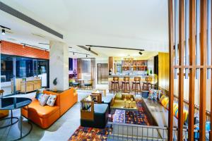 a living room with orange furniture and a bar at Amoravida By 7 Apple Resorts, Goa in Mandrem