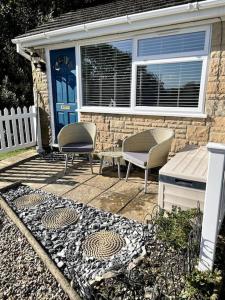 a patio with two chairs and a blue door at Self-catering studio in beautiful Charmouth in Charmouth