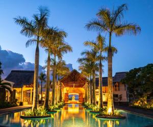 ośrodek z palmami i basenem w obiekcie Maritim Resort & Spa Mauritius w mieście Balaclava