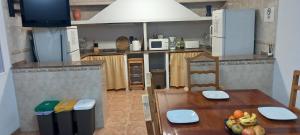 a kitchen with a wooden table and a kitchen with at Can Juvimar in El Poblenou del Delta