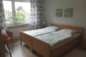 a bed sitting in a bedroom with a window at Ferienwohnung Illerhues in Ascheberg