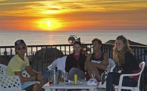 Hotel Eden في فياريجيو: مجموعة من الناس يجلسون على الكراسي ويشاهدون غروب الشمس