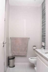 Johannesburg的住宿－Stunning 2 Bedroom Apartment，白色的浴室设有卫生间和毛巾。