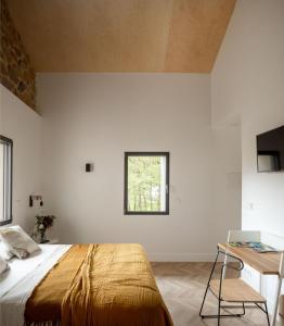 a bedroom with a bed and a table and a window at SOLOA LANDETXEA in Bakio