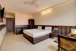 een slaapkamer met een bed en een bureau. bij FabHotel PS Grand in Lucknow