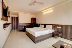 a bedroom with a bed and a flat screen tv at FabHotel PS Grand in Lucknow
