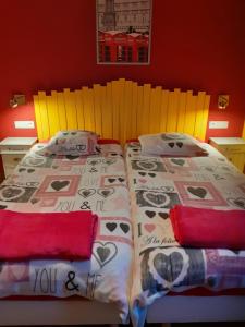 een slaapkamer met een bed met een sprei en kussens bij Au Temps de Spa Le 7 Heures in Spa