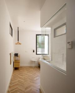 Habitación blanca con pasillo y ventana en SOLOA LANDETXEA en Bakio