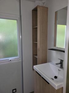 a bathroom with a sink and a window at Camping Les Chênes Verts in Meschers-sur-Gironde