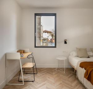 a bedroom with a bed and a desk and a window at SOLOA LANDETXEA in Bakio