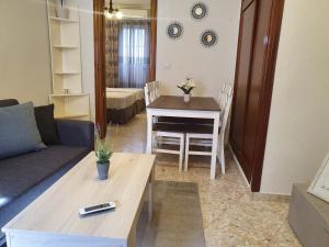 un salon avec un canapé et une table dans l'établissement LUNA-Guest Rooms, à Alcalá de Guadaira