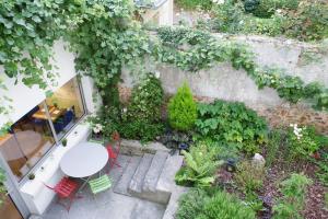 ベルサイユにあるホテル ダングルテールのテーブルと椅子付きの庭園の景色を望めます。