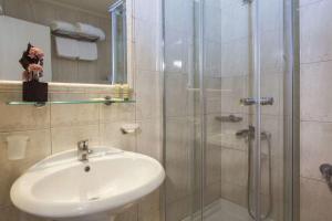 W łazience znajduje się umywalka i przeszklony prysznic. w obiekcie Leto Boutique Hotel Agrinio w mieście Agrinio