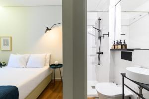 a bedroom with a bed and a shower and a sink at Maria da Sé Historic House in Porto +40 photos