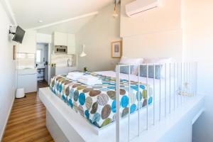 een slaapkamer met een bed in een witte kamer bij Maria da Sé Historic House in Porto