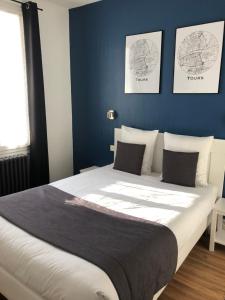 1 dormitorio con 1 cama grande y paredes azules en Hôtel Saint Eloi en Tours