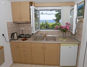 a kitchen with a sink and a window at Sunset Studios in Skala Marion
