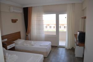 アイワルクにあるSeda Hotelのベッド2台と窓が備わるホテルルームです。