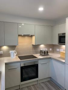 a kitchen with white cabinets and a stove top oven at 1/5 Lismore House in Oban