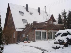 a wooden house with snow on the roof at Ritterkeller in Aspach