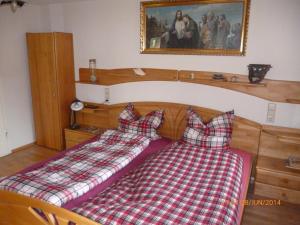 two beds in a room with a plaid blanket at Ritterkeller in Aspach