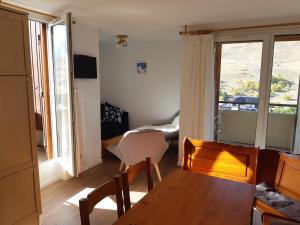 a living room with a table and chairs and a window at Boost Your Immo Les Ecrins 6 Les 2 Alpes 659 in Les Deux Alpes