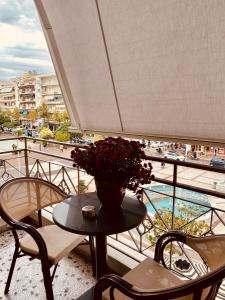 a table with a vase of flowers on a balcony at Central Rooms in Kalamata