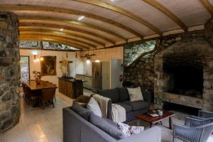 a living room with a couch and a stone fireplace at Kleinrivier Mountain Escapes in Uitenhage