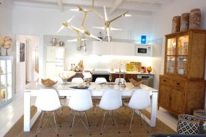 uma cozinha com uma mesa branca e cadeiras brancas em Ca na Kika 5 em Es Migjorn Gran