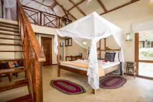 a bedroom with a bed and a canopy at Marafiki Bungalows in Kiwengwa