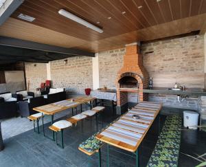 a restaurant with wooden tables and a brick oven at Camere De Inchiriat Carpati in Hunedoara
