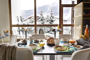 a table with food on it in front of a window at Belambra Clubs Praz-sur-Arly - L'Alisier in Praz-sur-Arly