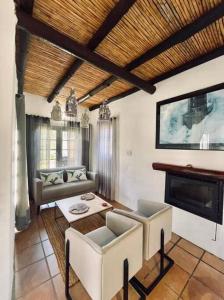 ein Wohnzimmer mit Sofa und Tisch in der Unterkunft Heron Cottage - Living The Breede in Malgas