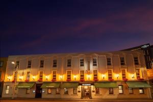 a large white building with lights on it at night at The Address Connolly in Dublin