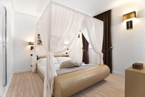 a bedroom with a canopy bed with white curtains at LHP Hotel Santa Margherita Palace & SPA in Santa Margherita Ligure