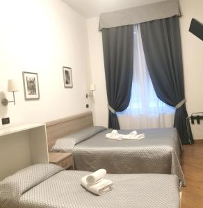 una camera d'albergo con due letti e una finestra di Hotel Chopin a Genova