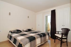 um quarto com uma cama, uma cadeira e uma janela em Castillo em Málaga