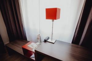 a lamp sitting on top of a wooden table at Art & Business Hotel in Nuremberg