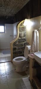 La salle de bains est pourvue de toilettes et d'un mur en pierre. dans l'établissement Sipi Coffee Lodge, à Kapchorwa