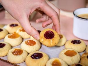 Una persona che prende un biscotto con la marmellata sopra. di Novotel London Wembley a Londra