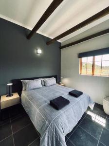 1 dormitorio con 1 cama con 2 toallas en Owl Cottage - Living The Breede, en Malgas