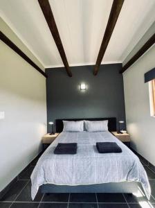 ein Schlafzimmer mit einem großen Bett mit zwei Nachttischen in der Unterkunft Owl Cottage - Living The Breede in Malgas
