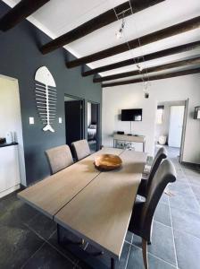 a dining room with a wooden table and chairs at Owl Cottage - Living The Breede in Malgas +29 photos