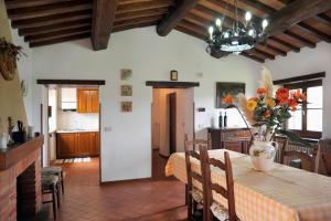 een eetkamer met een tafel met een vaas met bloemen erop bij San Lorenzo in Monte San Savino