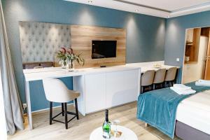 ハーネンクレー・ボックスヴィーゼにあるHaus am See Luxury HS 228 Bのベッドと机、テレビが備わったホテルの部屋