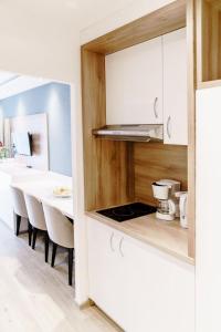 ハーネンクレー・ボックスヴィーゼにあるHaus am See Luxury HS 228 Bのキッチン(白いキャビネット、ダイニングテーブル付) +32枚の写真