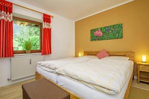 Un dormitorio con una cama grande y una ventana. en Ferienwohnung Schmankerl, en Reit im Winkl