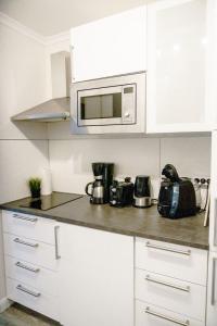 eine Küche mit weißen Schränken und einer Mikrowelle in der Unterkunft Haus am See HS 350 in Hahnenklee-Bockswiese