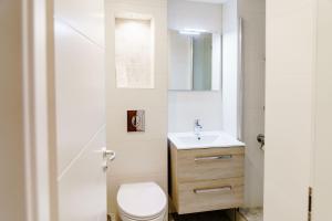 Un baño con un inodoro blanco y un lavabo. en Haus am See Luxury HS 226 B, en Hahnenklee-Bockswiese 26 fotos más